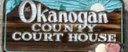 Wood carved sign with text "Okanogan County Court House"