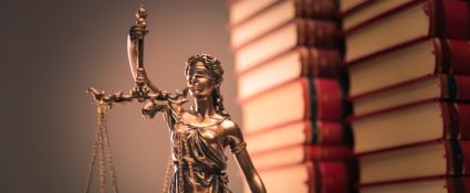 Lady Justice statue and law books- stock image.