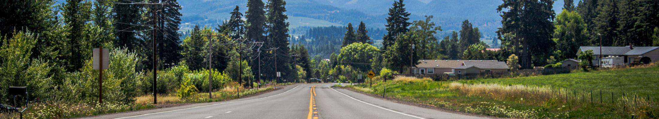 Paved road with mountain in the distance.